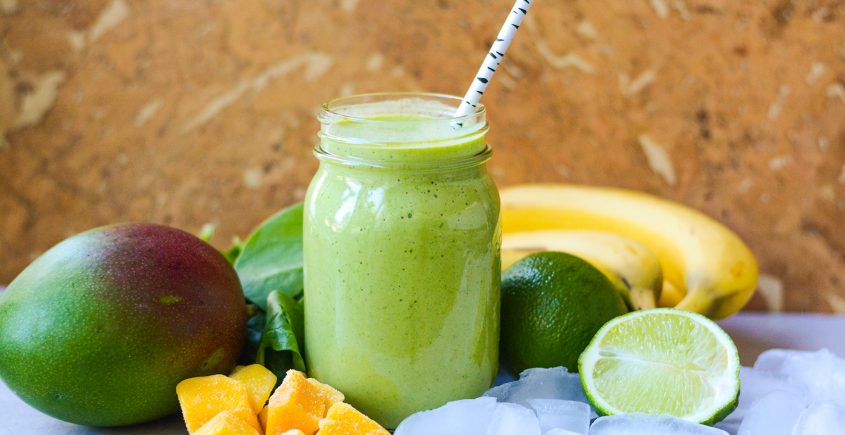 green smoothie with fruit, ice, and limes