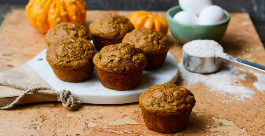 muffins on a table with flour and pumpkin